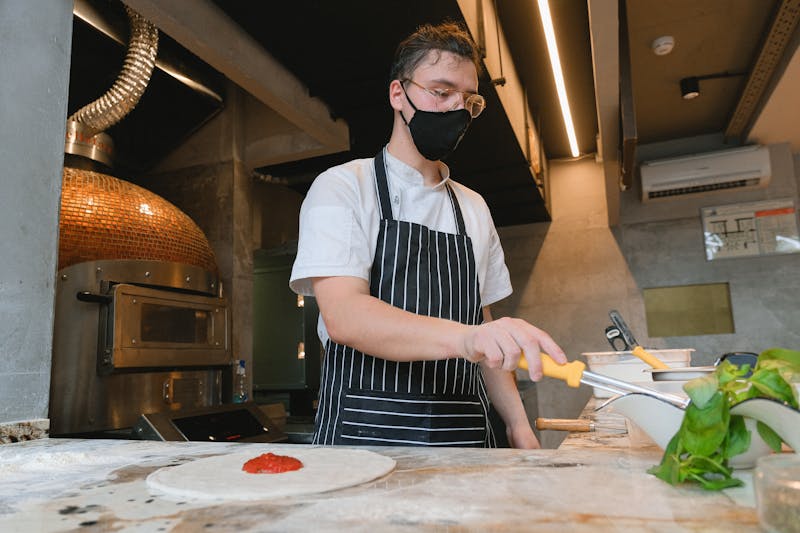 Round table pizza kitchen — handcrafted pizza being prepared